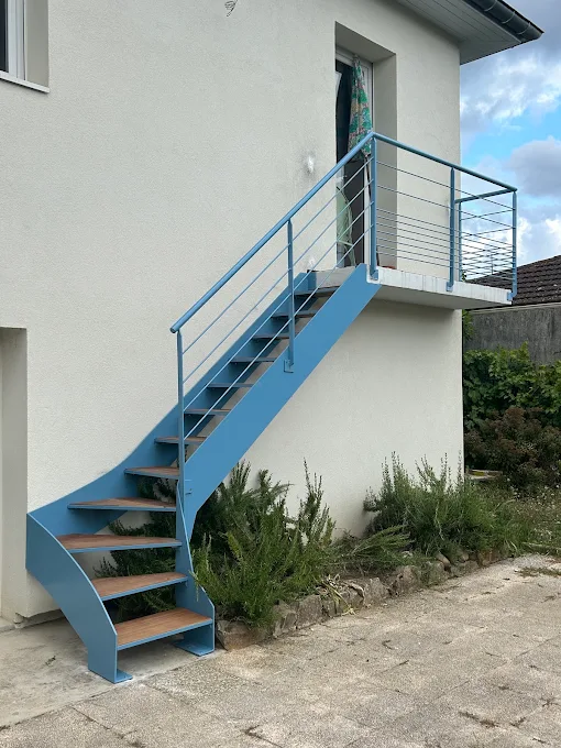 Réalisation de métallerie : escalier extérieur bleu et garde-corps à câbles